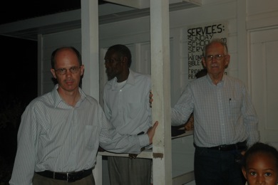 men visiting on Church of God chapel porch.